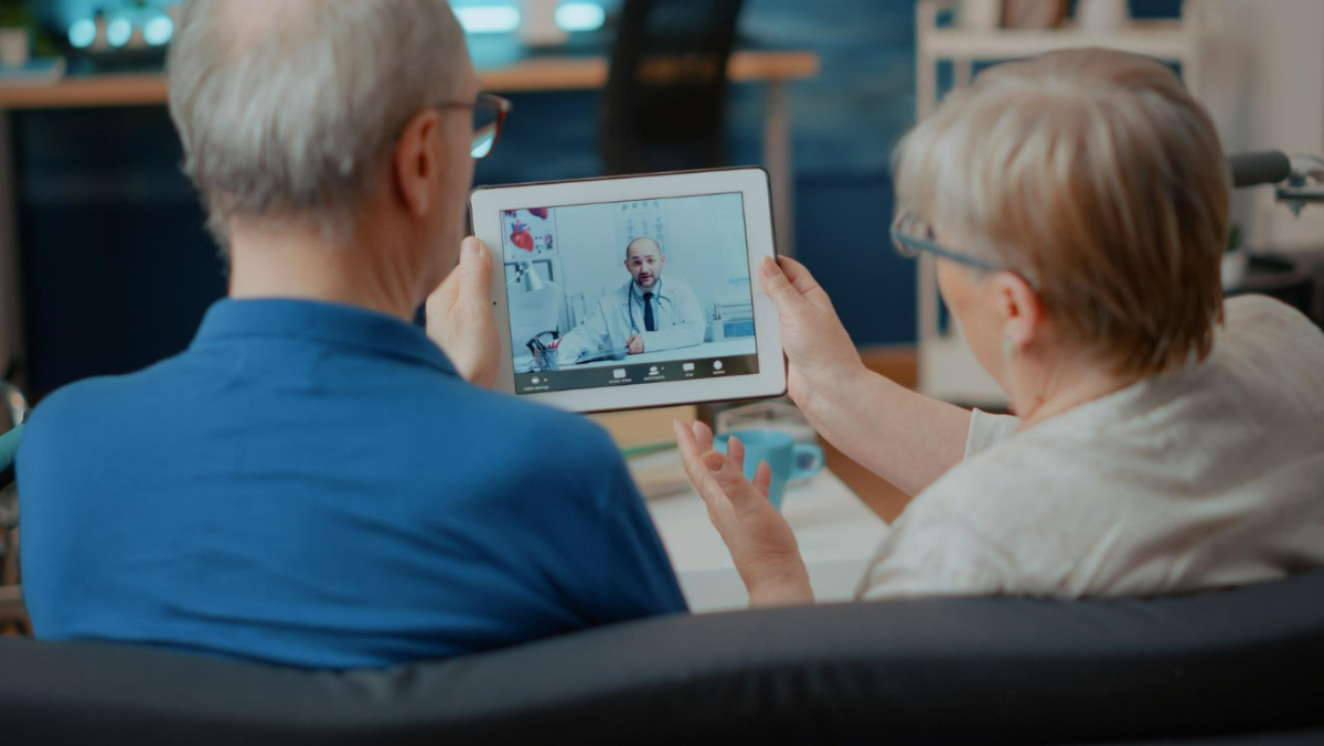 Older couple having a telehealth video call with a doctor on a tablet