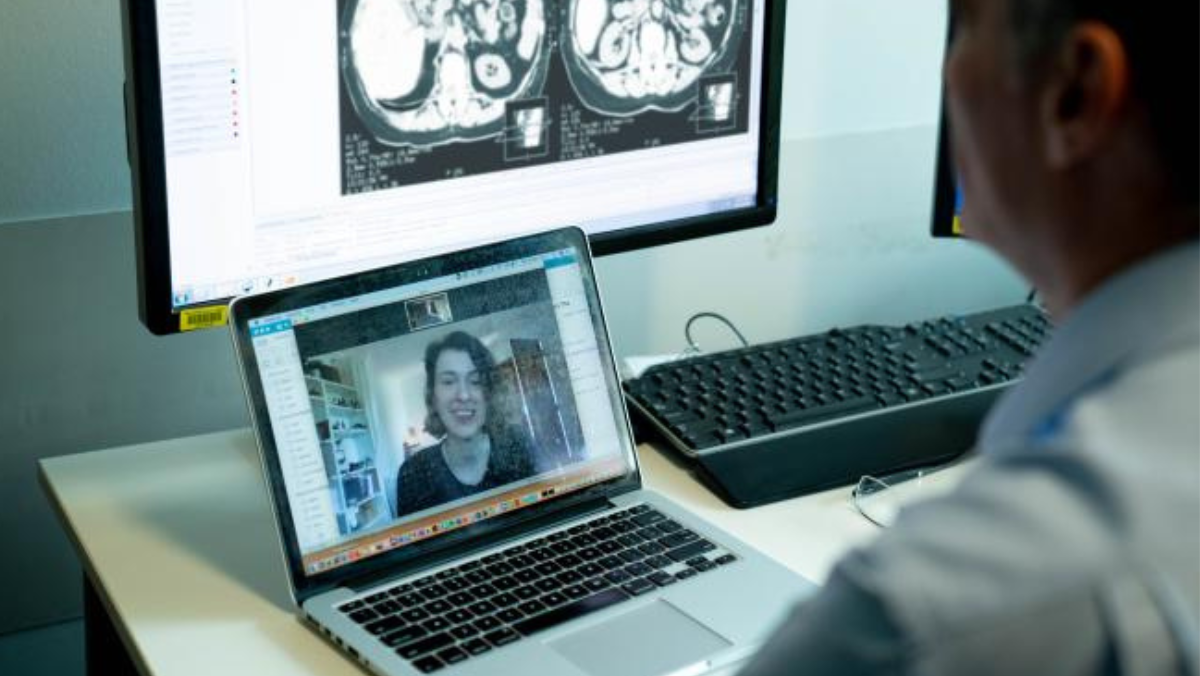 Clinician conducting telehealth video consult with medical images displayed on screen